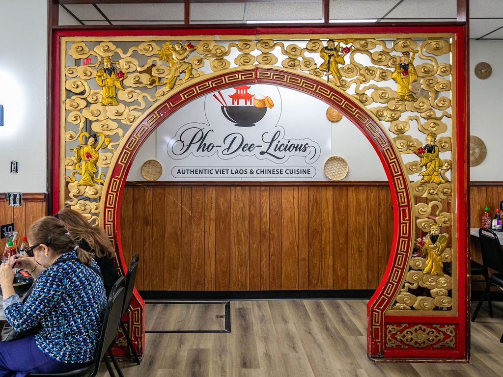 Red and gold moon gate arch inside Pho Dee-Licious with the restaurant sign