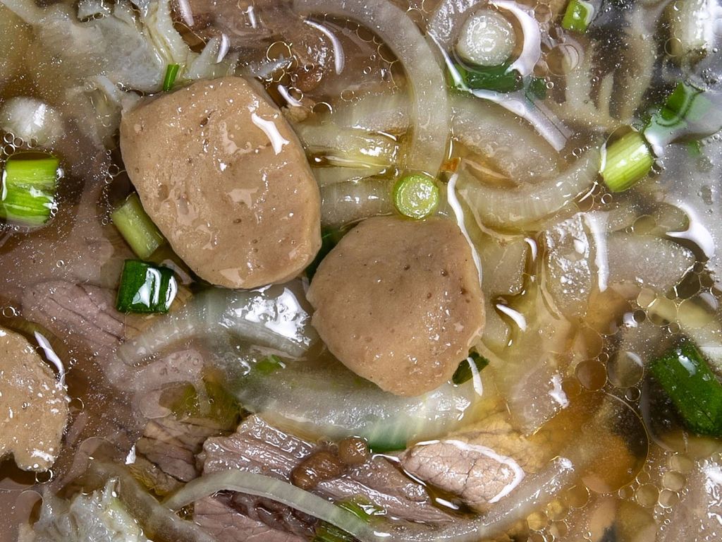 Close up of beef pho with brisket, meatballs and onions